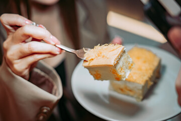 Indulgent Bite of Cake: Capturing a moment of pure pleasure, a hand delicately lifts a forkful of...