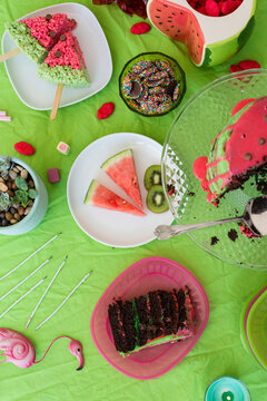 overhead of watermelon theme party, including cake, watermelon, lollies
