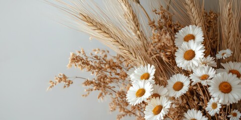 Natural and organic arrangement with dried daisies and fluffy wheat stalks.
