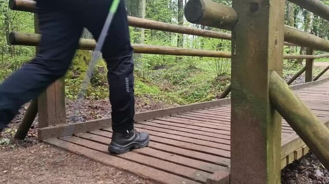 Tourists walk in sigulda nature park across the wooden pedestrian bridge.