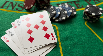 A popular and exciting poker game with a winning combination. Playing cards and chips on a table in...