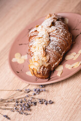 Сake croissant with chocolate with powder and almonds nuts and raisins.