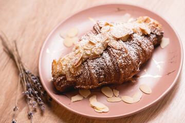 Сake croissant with chocolate with powder and almonds nuts and raisins.
