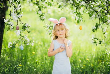 childhood, Easter celebrations, and seasonal happiness, Easter egg hunt. Girl child Wearing Bunny...
