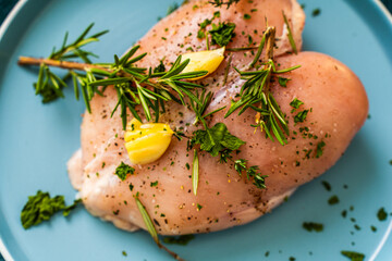 Raw chicken breast marinated with rosemary, garlic and herbs on a white background and vacuum bag.