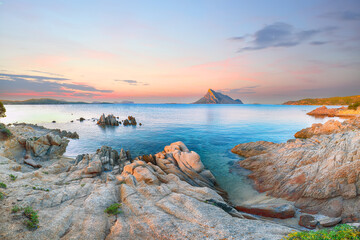 Superb evening scene of Porto Taverna beach with Tavolara mountain on background.