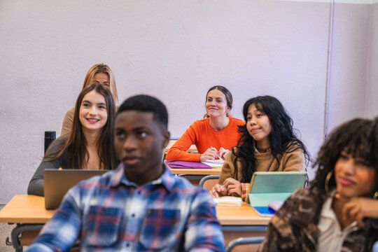 High school students listening to teacher in classroom