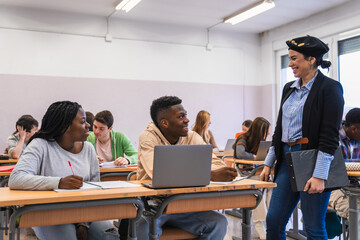 Fototapeta premium High school students learning and interacting with teacher in classroom