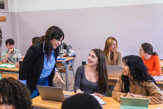 High school teacher interacting with students in classroom - Powered by Adobe
