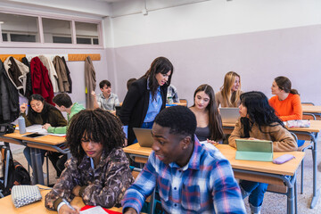High school teacher helping students studying and learning in classroom