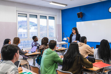 Obraz premium High school teacher giving lesson to students in classroom