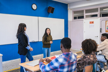 High school student giving presentation to classmates and teacher