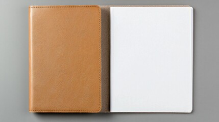Top view of an open notebook with a brown cover and blank pages on a gray background.