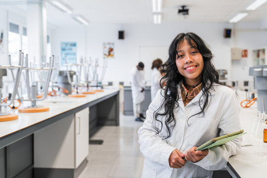 Young female chemistry student smiling in university lab