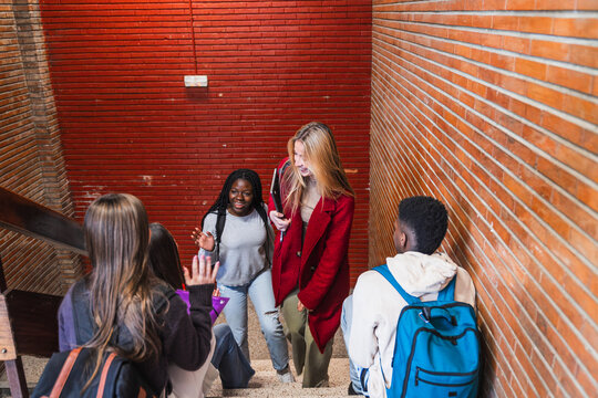 High school students walking and talking on stairs