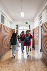 High school students walking down school corridor after class