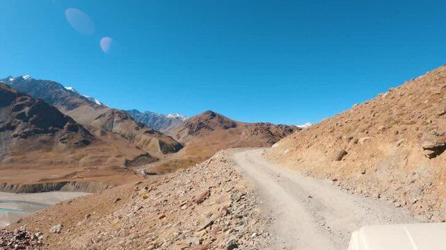 4K POV Hyper lapse shot of a vehicle moving on a narrow dirt road on the side of the Himalayan mountain on the way towards Chandratal in Spiti Valley, Himachal Pradesh, India. Rural road in Himalayas.