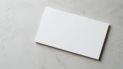 Blank white card on a smooth, light gray surface, perfect for branding or design mockup.