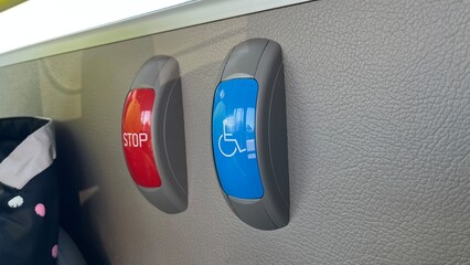 Bus stop request buttons. Red "STOP" and blue accessibility symbol on a bus interior wall