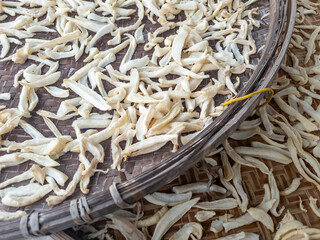 Close up of Lo Pak, mooli or turnips, on a woven bamboo tray drying out in the sun.