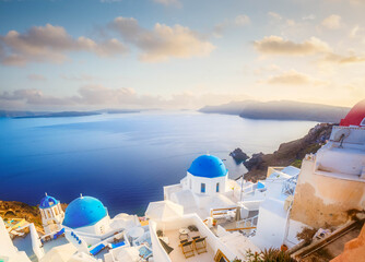 traditional greek village Oia of Santorini, with blue domes of churches and village street, Greece