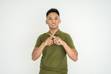 young Asian man in a green shirt makes a hand gesture indicating refusal or disapproval. The person...