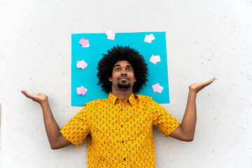 Young man wearing yellow shirt, blue indicating label with arrow signs