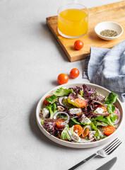 Vegetable salad (Greek salad) with tomatoes, cheese, lettuce, olives and onion in a plate