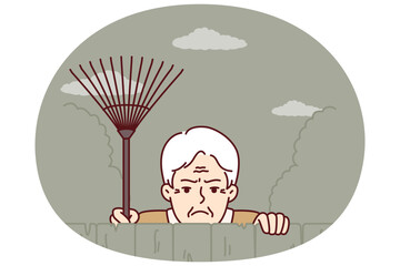 Elderly envious man neighbor peeps from behind fence spying on residents of private house. Envious male pensioner with rake looking at screen suspiciously for bad neighborhood concept.