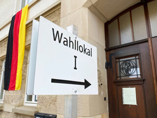 Bundestagswahl, Eingang zum Wahllokal mit Deutschlandfahne im Hintergrund