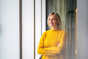 Self-confident woman in a modern office wearing a yellow sweater