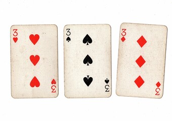 A hand of vintage playing cards showing three of the same value on a white bckground.