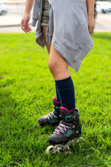 Teenager wearing inline skates standing on grass in urban park