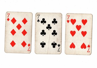 A hand of vintage playing cards showing three of the same value on a white bckground.