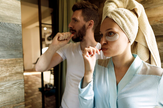 A couple brushing their teeth together in the bathroom as part of their morning routine