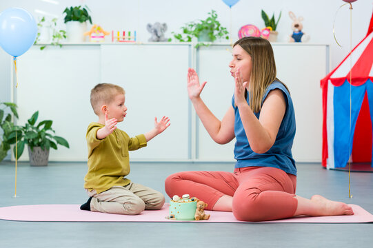 Baby Sign Language. Nonverbal child learning to sign with the help of a speech therapist. Child therapy, neurodiversity, learning difficulty, developmental disability.
