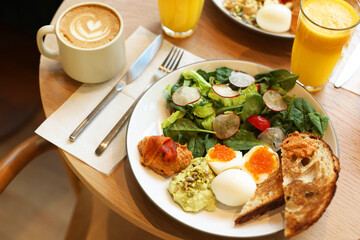 Tasty breakfast. Salad and eggs with red caviar served on wooden table in cafe, closeup