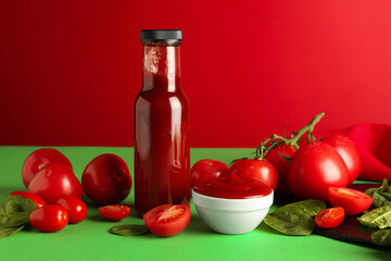 Ketchup, tomatoes and spinach on color background