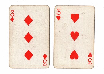A pair of vintage playing cards of the same value on a white background.