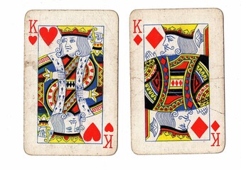 A pair of vintage playing cards of the same value on a white background.