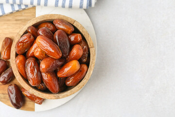 Tasty dried dates in bowl on white table, top view. Space for text