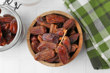 Tasty dried dates on white tiled table, top view