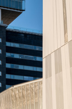 Close-up of a modern building corner with dynamic angles and reflective surfaces, highlighting urban architectural aesthetics.