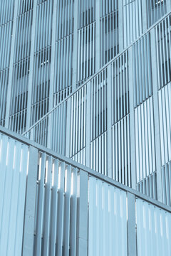 Close-up of a contemporary glass and metal facade with vertical lines and reflections, emphasizing modern urban design.