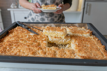 Woman serving a fresh and homemade baked coconut sponge cake