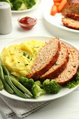 Delicious baked turkey meatloaf with mashed potato served on white wooden table, closeup