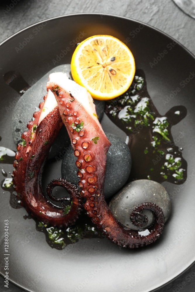 Sticker Fried octopus with herb sauce and lemon served on grey table, top view