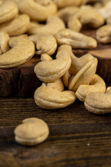 large cashew nuts are scattered on a larch board