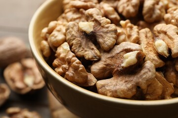 Peeled walnuts in bowl on table, closeup