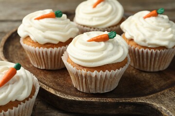 Delicious carrot cupcakes on wooden table, closeup